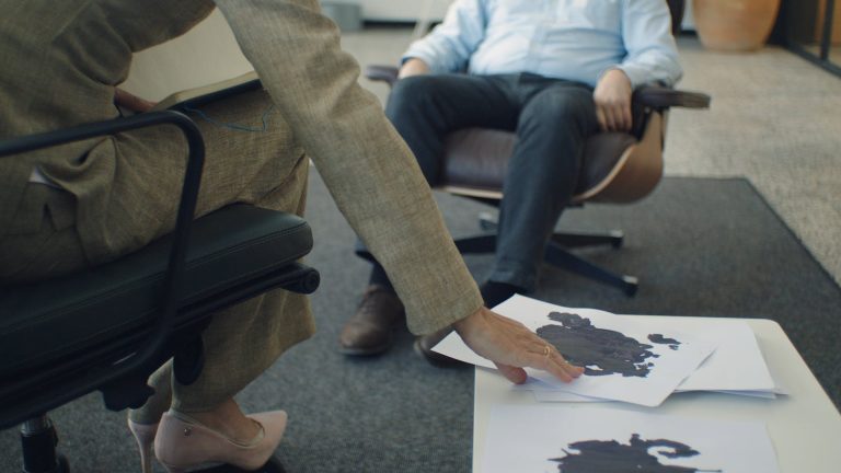 A therapy session with focus on inkblot psychology test and patient interaction.